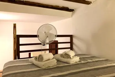 a bedroom with a bed with towels and a fan at Piazza Marina Apartment in Palermo
