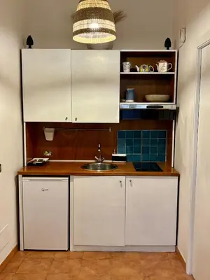 a kitchen with white cabinets and a sink at Piazza Marina Apartment in Palermo