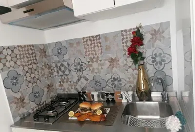 a kitchen counter with a sink and a stove with food on it at Historic Centre - Apartment Near Teatro Massimo in Palermo