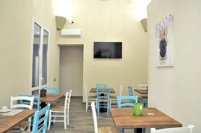 a restaurant with wooden tables and chairs and a flat screen tv at Arsenale Porto in Palermo