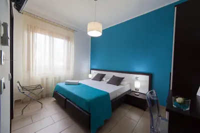 a blue bedroom with a bed and a blue wall at Kristal in San Vito lo Capo