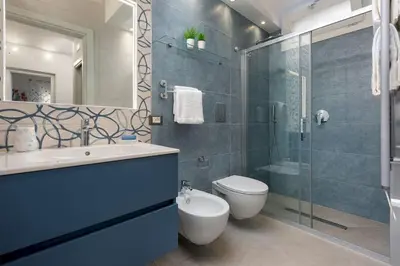a bathroom with a toilet and a glass shower at Alofara Apartment in San Vito lo Capo