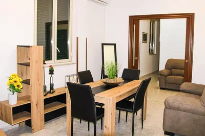 a living room with a wooden table and chairs at Gabry central apartment Palermo in Palermo