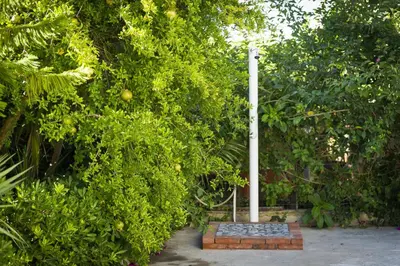 a pole in the middle of a garden with trees at La Perla del Golfo in Castellammare del Golfo