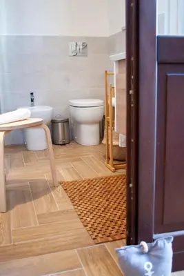 a bathroom with a toilet and a table at La casa di Nemi a San Vito in San Vito lo Capo