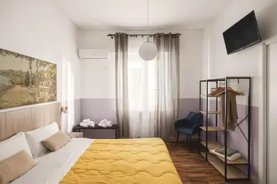 a bedroom with a bed with a yellow blanket at Dante Suites in Palermo