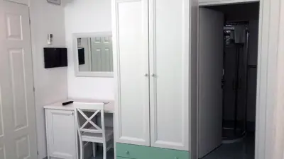 a white bathroom with a desk and a mirror at Le Camere della Campana in Castellammare del Golfo
