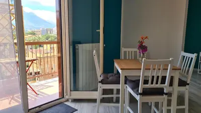 a dining room with a table and chairs and a balcony at Alberira Apartments in Palermo