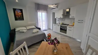 a bedroom with a bed and a table in a kitchen at Alberira Apartments in Palermo