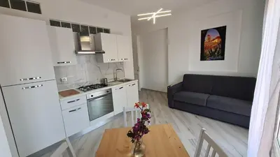 a kitchen and living room with a couch and a table at Alberira Apartments in Palermo
