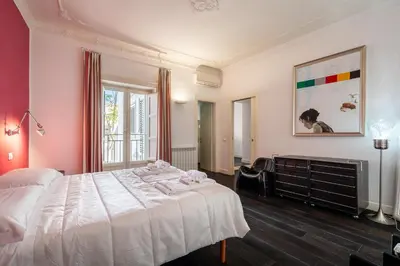 a bedroom with a large white bed and a window at Celestre all'Alloro by DomuSicily in Palermo