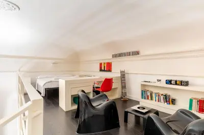 a bedroom with a bed and a desk and chairs at Celestre all'Alloro by DomuSicily in Palermo