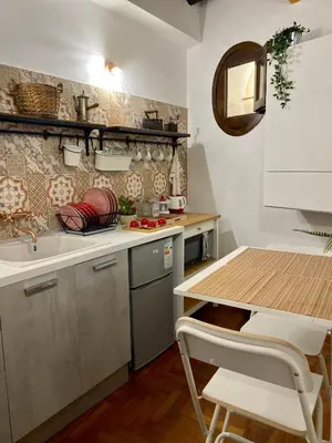 a kitchen with a sink and a table with chairs at Cathedral Sweet home in Palermo