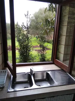 a sink in a window with a view of a field at casale guidaloca in Castellammare del Golfo