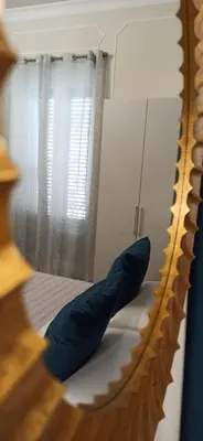 a mirror with a blue pillow sitting on a bed at Amaris in Palermo