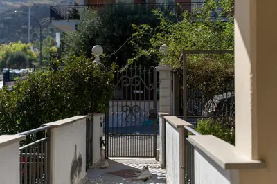 two pigeons sitting on the sidewalk in front of a gate at Click Art & Room in Trabia