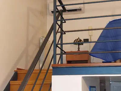 a staircase with a blue railing with a clock on it at Palermo Centrocittà in Palermo