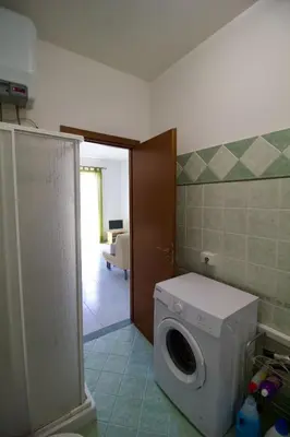 a bathroom with a washing machine in a room at Salina in Trappeto