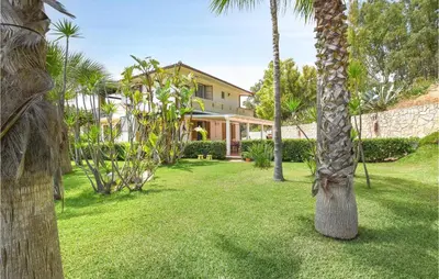 a palm tree in the yard of a house at Pet Friendly Home In Balestrate in Balestrate
