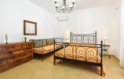 a bedroom with two beds and a dresser and a mirror at Pet Friendly Home In Balestrate in Balestrate