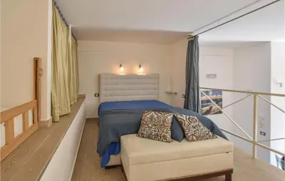 a bedroom with a bed and a chair and a balcony at Pet Friendly Home In Balestrate in Balestrate