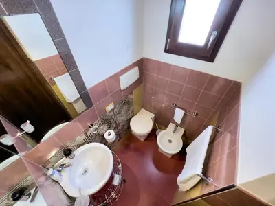 a bathroom with a sink and a toilet and a mirror at Sicilia Ovest - Sea View Terrace Sofia in Castellammare del Golfo