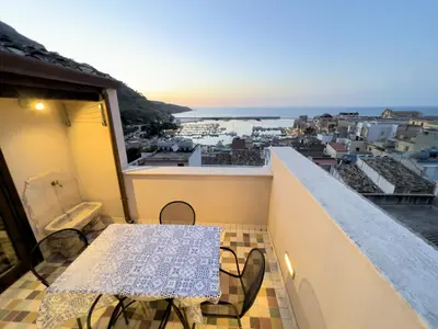 a balcony with a table and a view of a city at Sicilia Ovest - Sea View Terrace Sofia in Castellammare del Golfo