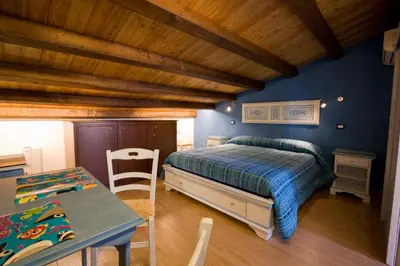a bedroom with a bed and a table and chairs at Sicilia Ovest - Sea View Balcony Cerri in Castellammare del Golfo