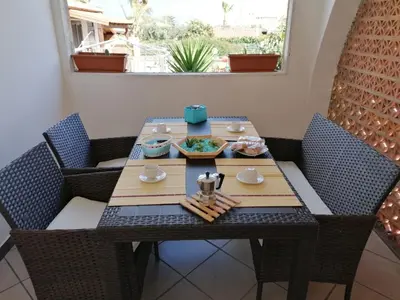 a table and chairs with a meal on it at Momaliar House in Campofelice di Roccella