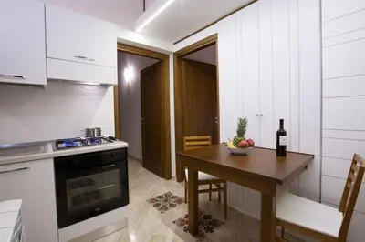 a small kitchen with a table and a bottle of wine at Sicilia Ovest - Terrazza Orologio e Terrazza Sul Mare in Castellammare del Golfo