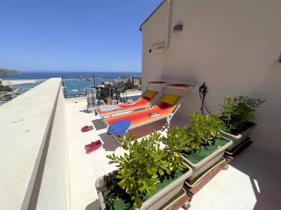 a balcony with a bed on the side of a building at Sicilia Ovest - Terrazza Orologio e Terrazza Sul Mare in Castellammare del Golfo