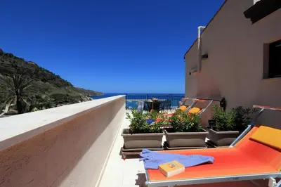 a balcony with chairs and plants on a building at Sicilia Ovest - Sea View Terrace Dolce Vita in Castellammare del Golfo