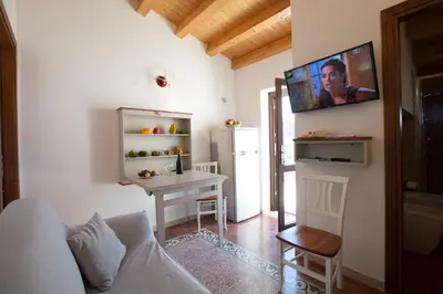 a living room with a table and a tv on the wall at Sicilia Ovest - Sea View Terrace Dolce Vita in Castellammare del Golfo