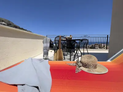a hat on a table with a view of the ocean at Sicilia Ovest - Sea View Terrace Dolce Vita in Castellammare del Golfo