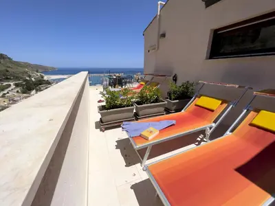 a balcony with chairs and tables on a building at Sicilia Ovest - Sea View Terrace Dolce Vita in Castellammare del Golfo