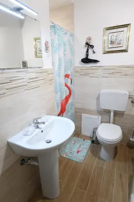 a bathroom with a white sink and a toilet at By the Sea Apartment #4 in Terrasini