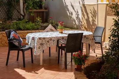 a table with chairs and a table cloth on a patio at La Palma in San Vito lo Capo