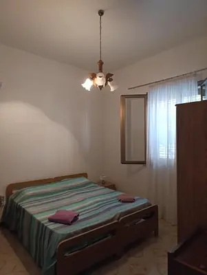 a bedroom with a bed and a chandelier at Villa Giardini in Balestrate