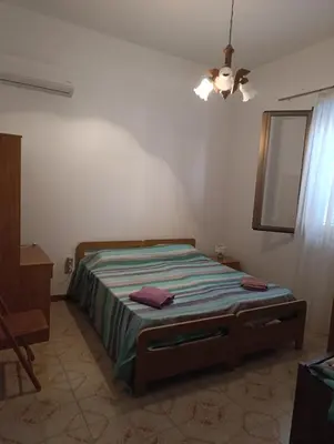 a bedroom with a bed with a green blanket at Villa Giardini in Balestrate