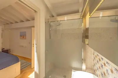 a glass shower in a room with a bed at Design loft Marinella in Porticello in Santa Flavia