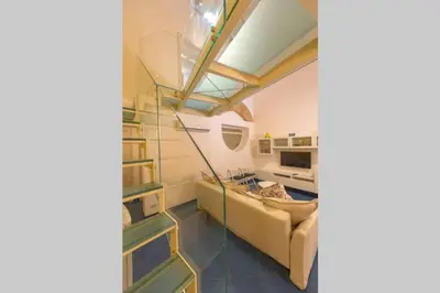 a living room with a couch and a staircase at Design loft Marinella in Porticello in Santa Flavia