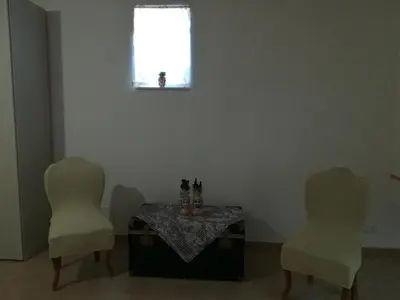 two chairs and a table in a room with a window at Casa Vacanza Da Sofì in Cerda
