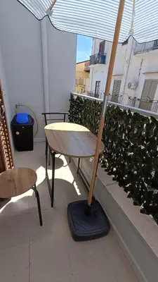 a table with an umbrella on top of a balcony at casa francesca 2 LOFTY in Castellammare del Golfo