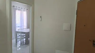 a door leading to a room with a table and a window at casa francesca 2 LOFTY in Castellammare del Golfo