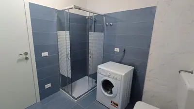 a bathroom with a washing machine and a shower at casa francesca 2 LOFTY in Castellammare del Golfo