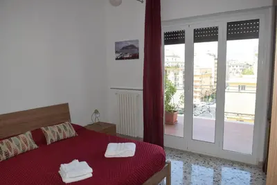 a bedroom with a red bed and a sliding glass door at Villabianca Vacanze in Palermo