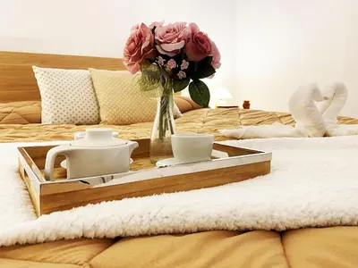 a tray with a vase of flowers on a bed at Villabianca Vacanze in Palermo
