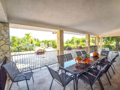 a patio with a table and chairs on a balcony at Villa La Vela by Interhome in Scopello