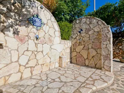 a stone wall with a stone door in a yard at Holiday Home Melograno di Patrizia by Interhome in Castellammare del Golfo