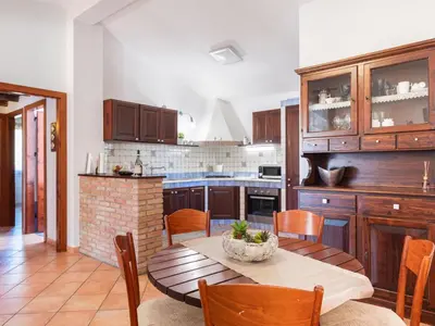 a kitchen with a table and chairs and a kitchen with a counter at Villa Nicole con Dependance by Interhome in Castellammare del Golfo